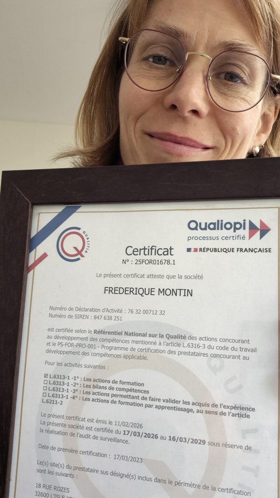 Smiling woman with round glasses holding a framed certificate for quality certification qualiopi in front of her face